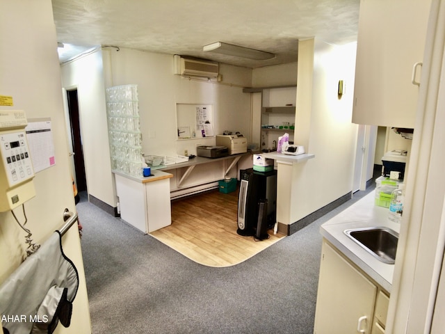 kitchen with a wall mounted air conditioner, a textured ceiling, dark hardwood / wood-style flooring, and sink