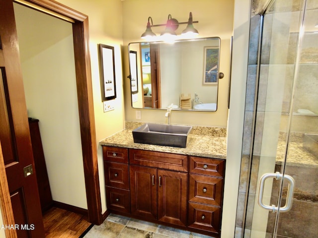 bathroom featuring hardwood / wood-style floors, vanity, and walk in shower