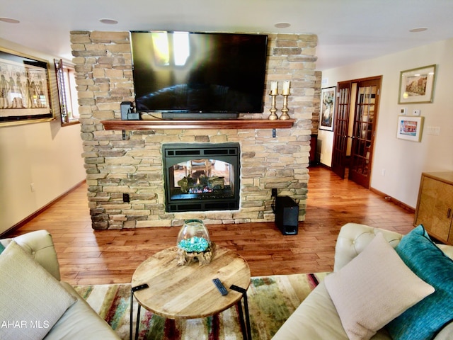 living room featuring wood-type flooring, a fireplace, and french doors