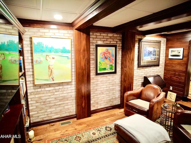 sitting room with wooden walls and light hardwood / wood-style floors