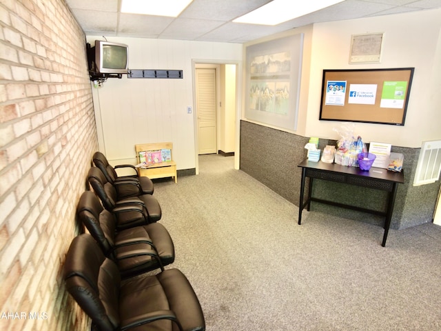 carpeted living room featuring a paneled ceiling