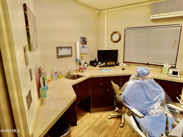 office featuring an AC wall unit, sink, and light wood-type flooring