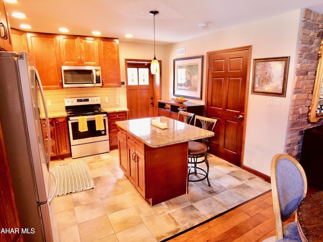 kitchen with light wood-type flooring, range with electric cooktop, decorative light fixtures, a center island, and white fridge