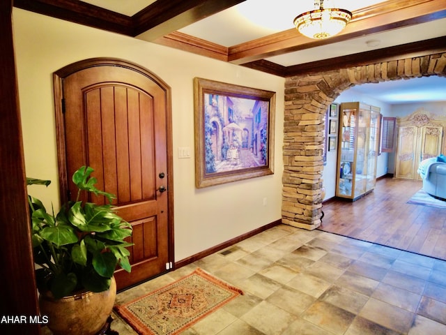 foyer featuring beamed ceiling, light wood-type flooring, and crown molding