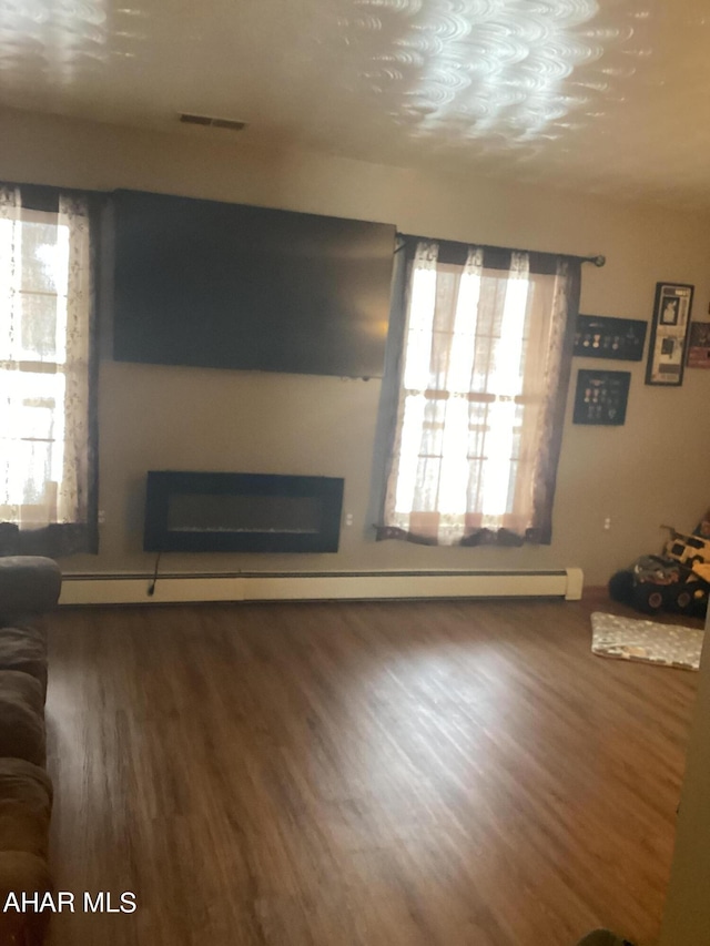 living room with hardwood / wood-style flooring and baseboard heating