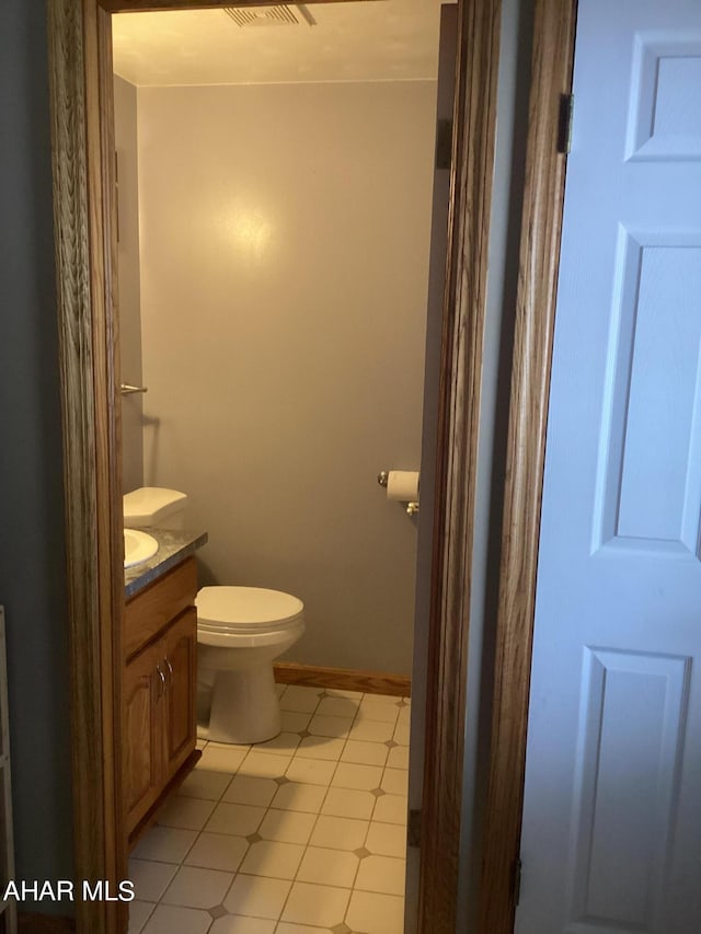 bathroom with tile patterned flooring, vanity, and toilet