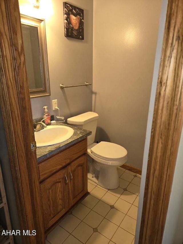 bathroom with tile patterned flooring, vanity, and toilet