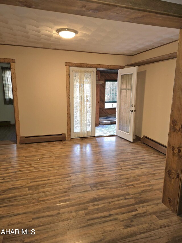 spare room featuring hardwood / wood-style flooring, french doors, and a baseboard radiator