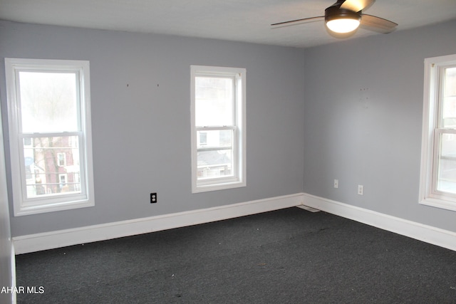 carpeted spare room featuring ceiling fan