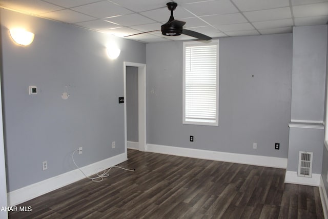 spare room with a paneled ceiling, ceiling fan, and dark hardwood / wood-style flooring