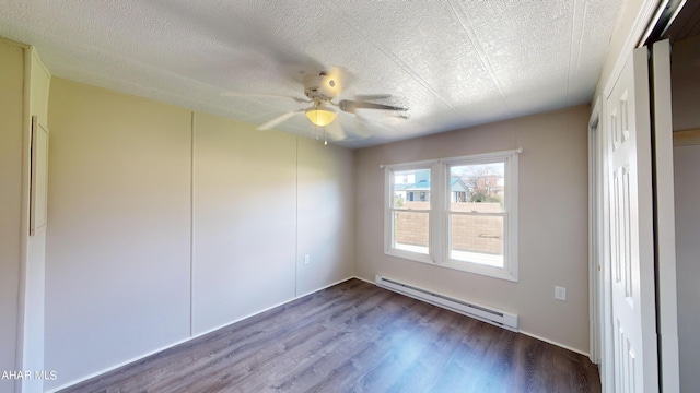 spare room featuring ceiling fan, wood-type flooring, a textured ceiling, and a baseboard heating unit