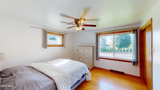 bedroom with light hardwood / wood-style flooring, multiple windows, and ceiling fan