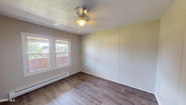 unfurnished room with baseboard heating, ceiling fan, wood-type flooring, and a textured ceiling