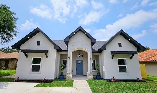 1211 S Cherry Blossom Cir, Weslaco, TX 78596 - view of front of home with stucco siding, a front lawn, and a shingled roof