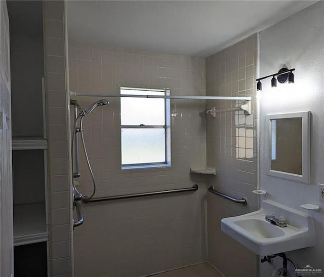 bathroom featuring a tile shower and sink