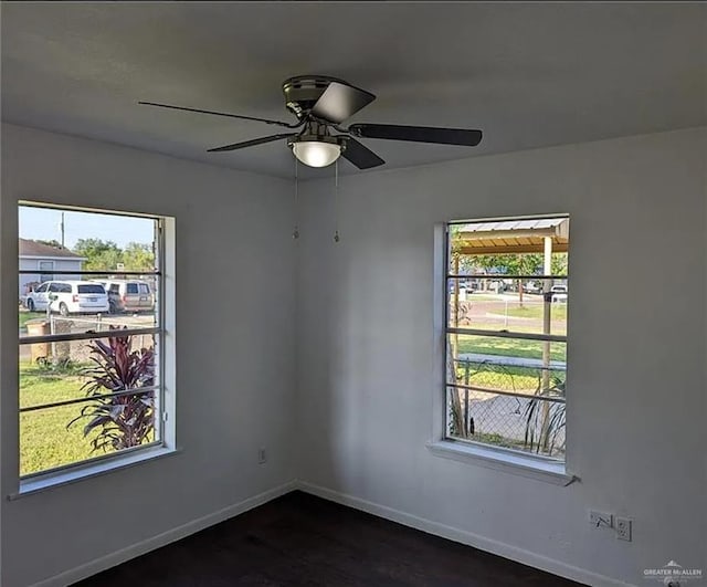 spare room featuring ceiling fan, a healthy amount of sunlight, and dark hardwood / wood-style floors