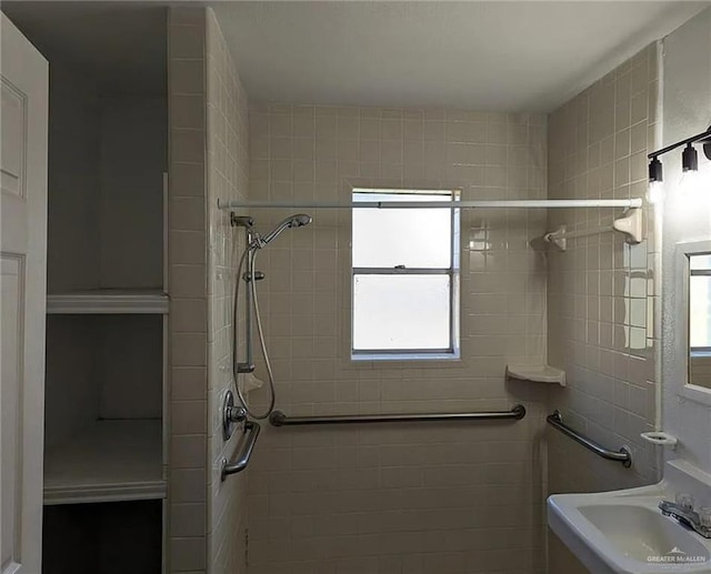 bathroom with tiled shower and sink