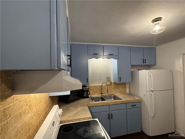 kitchen with stove, sink, decorative backsplash, a textured ceiling, and white fridge