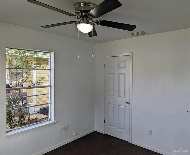 unfurnished bedroom with ceiling fan, dark hardwood / wood-style floors, a closet, and multiple windows