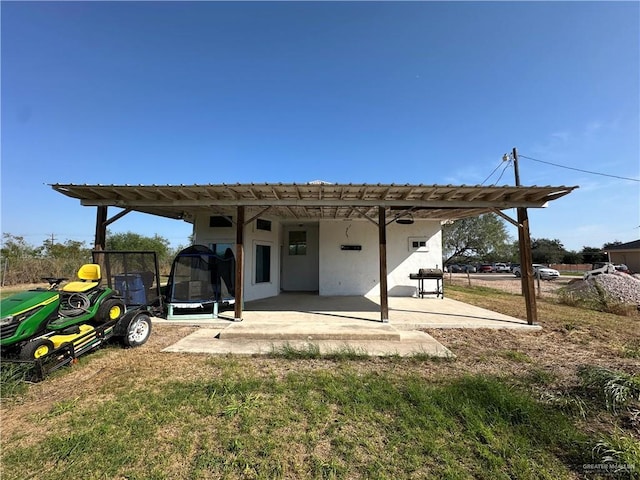 back of property featuring a patio and a trampoline