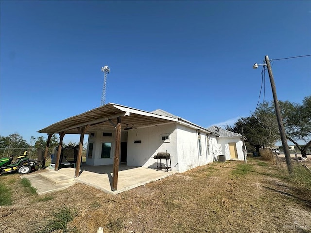 rear view of house featuring central air condition unit and a patio