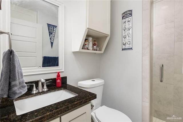 bathroom with toilet, vanity, and walk in shower