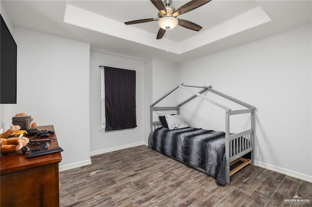 bedroom featuring ceiling fan and a raised ceiling