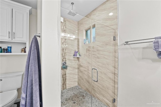 bathroom with toilet and a shower with shower door