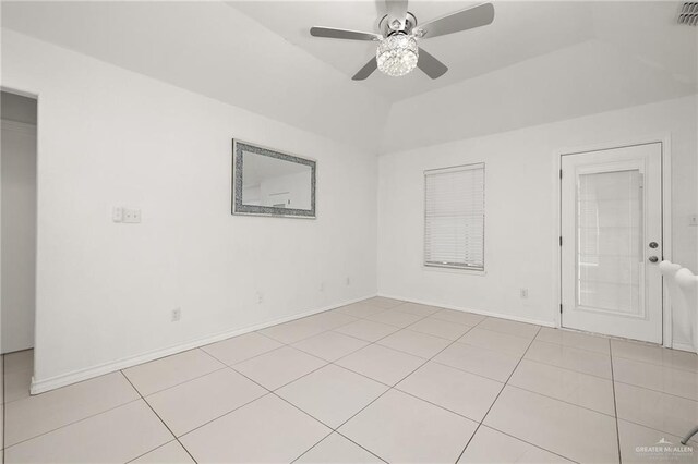 empty room featuring ceiling fan, light tile patterned floors, and vaulted ceiling