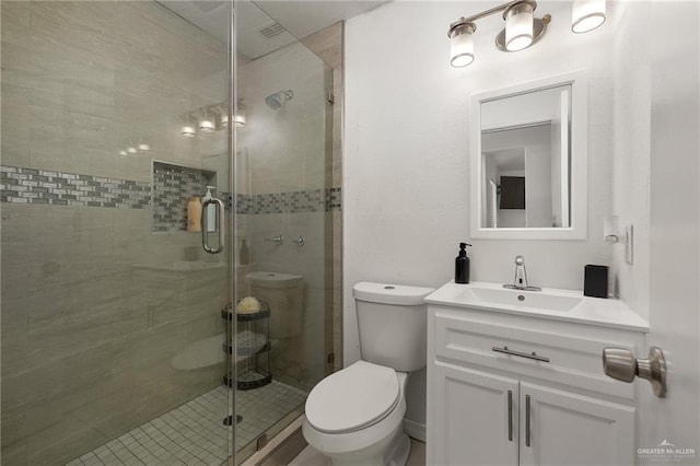 bathroom featuring vanity, an enclosed shower, and toilet