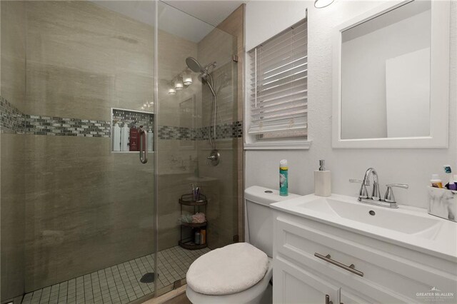 bathroom featuring vanity, toilet, and a shower with door