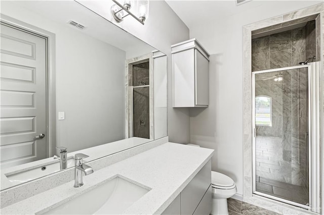 bathroom featuring vanity, an enclosed shower, and toilet