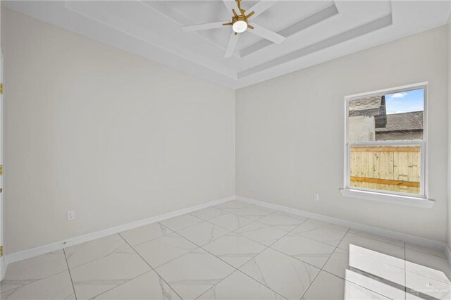 3003 E Palo Blanco St, Hidalgo, TX 78557 - unfurnished room featuring baseboards, light marble finish floors, ceiling fan, and a tray ceiling
