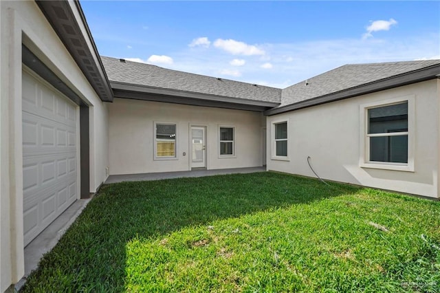 3003 E Palo Blanco St, Hidalgo, TX 78557 - back of house with a garage, a yard, stucco siding, and a shingled roof