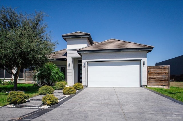 view of front facade featuring a tiled roof, a garage, and driveway