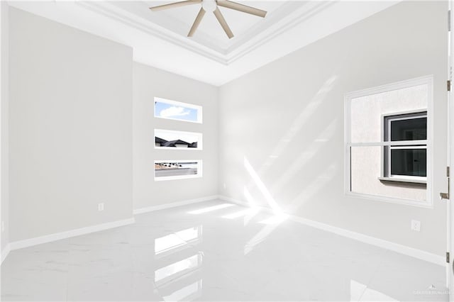 empty room featuring ceiling fan, ornamental molding, and a raised ceiling