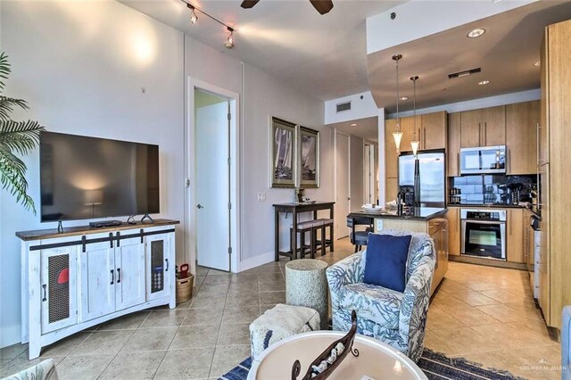 310A Padre Blvd, South Padre Island, TX 78597 - kitchen with backsplash, a center island with sink, hanging light fixtures, ceiling fan, and stainless steel appliances