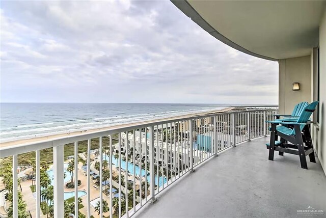 balcony featuring a water view and a beach view