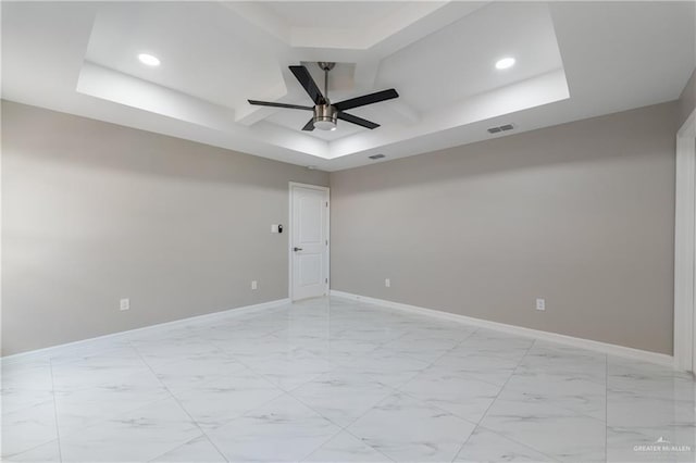 spare room featuring coffered ceiling, a raised ceiling, and ceiling fan