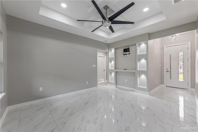 unfurnished living room featuring a raised ceiling and ceiling fan with notable chandelier