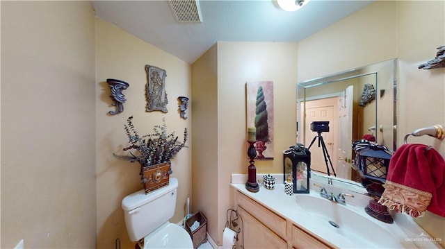 bathroom featuring visible vents, vanity, and toilet