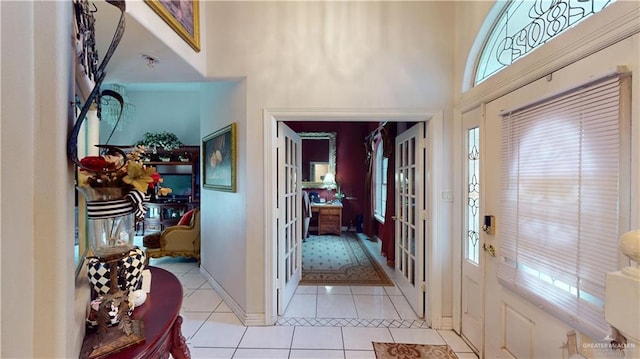 entrance foyer featuring light tile patterned floors and a high ceiling