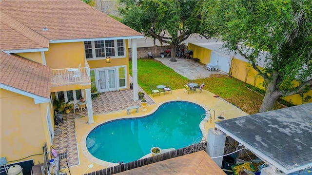 view of pool featuring a fenced backyard, a yard, french doors, a fenced in pool, and a patio area