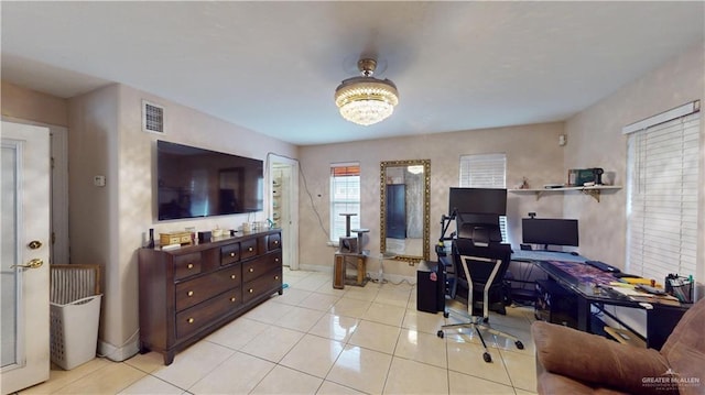 office space with baseboards, visible vents, a notable chandelier, and light tile patterned flooring