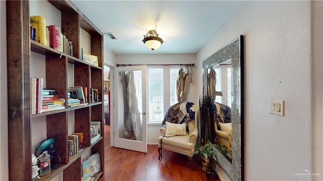 sitting room with visible vents, wood finished floors, and french doors