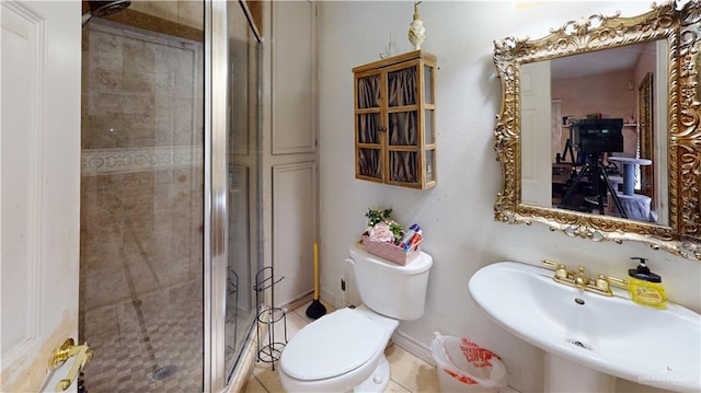 bathroom featuring toilet, a shower stall, baseboards, and a sink