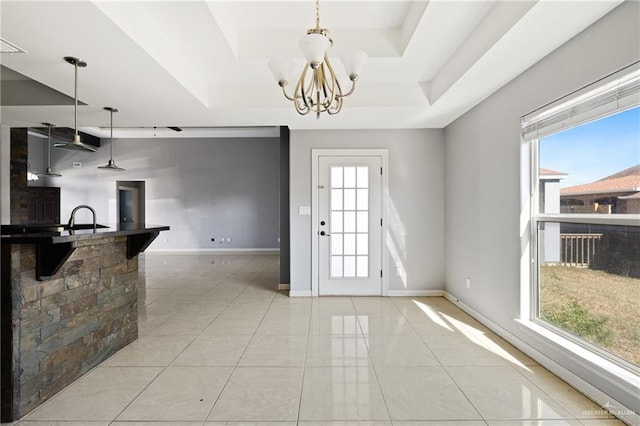 tiled dining room with plenty of natural light, a chandelier, and a tray ceiling