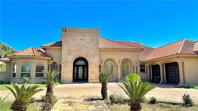 mediterranean / spanish house featuring a garage and french doors