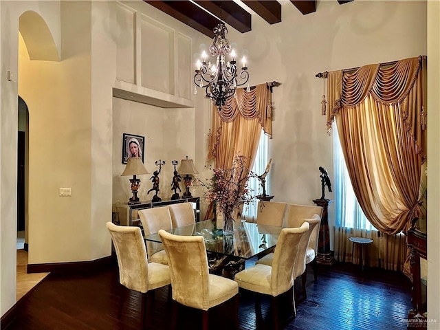 dining room with an inviting chandelier, dark hardwood / wood-style flooring, and beamed ceiling