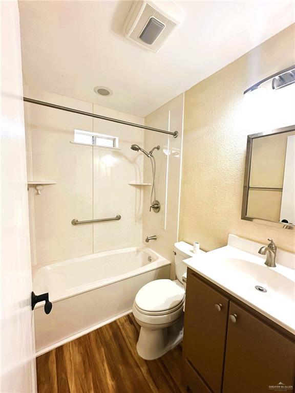 full bathroom with bathtub / shower combination, wood-type flooring, toilet, and vanity